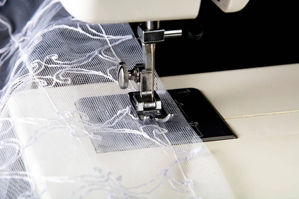 Siyah arkaplanda tül olan dikiş makinesi.