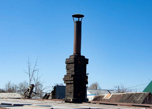 Ocaktan tuğlalarla kaplı eski bir demir boru..