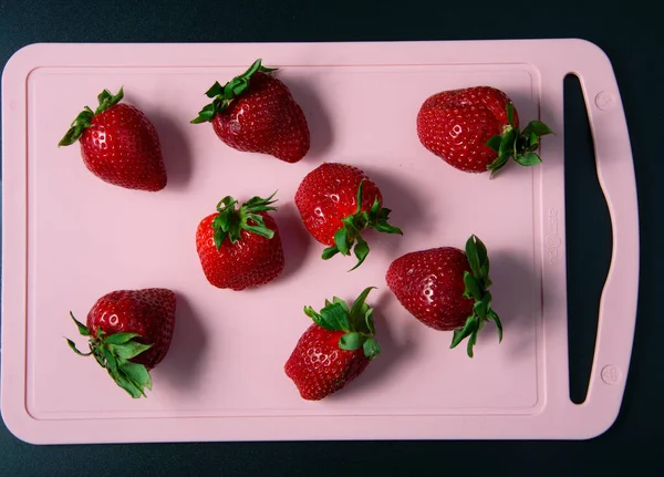Rote Saftige Erdbeeren Auf Einem Rosa Schneidebrett — Stockfoto