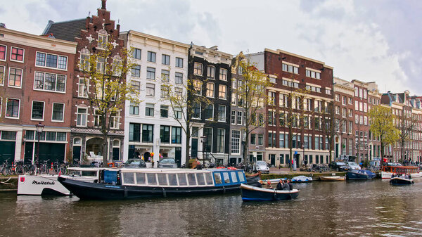 Amazing colorful cityscape of Amsterdam with boats on canal