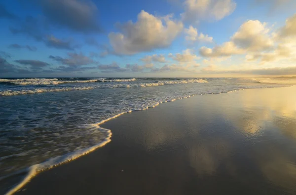 Playa paradisíaca con agua clara al atardecer Imagen de stock