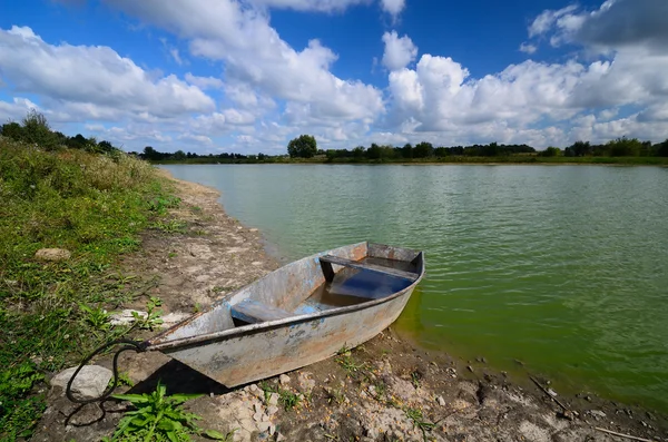川岸で錆びたボート — ストック写真