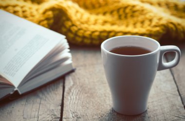Beyaz fincan çay, kitap ve eşarp eski ahşap masa