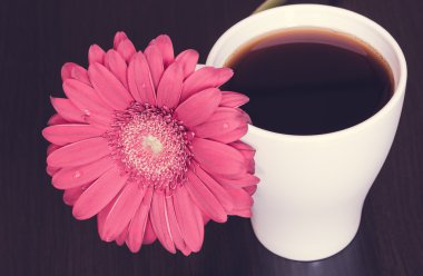 Pembe gerbera çiçek ve ahşap masa kahve