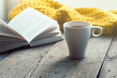 Beyaz fincan çay, kitap ve eşarp eski ahşap masa