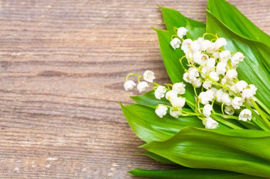 Ahşap arka plan üzerinde vadideki zambak buketi. Bahar
