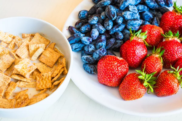 Zdrowe śniadanie. Płatki kukurydziane z dojrzałych truskawek czerwony i niebieski — Zdjęcie stockowe
