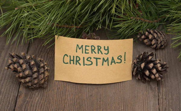 Cartão de saudação "Feliz Natal" escrito em papel kraft com abeto — Fotografia de Stock
