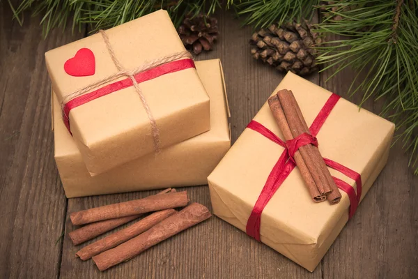 Cartão de Natal com três presentes, canela e abeto em madeira — Fotografia de Stock