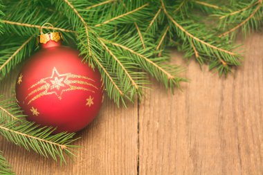 Çam ağacı ve Noel ile yılbaşı kartı ahşap ba üzerinde kırmızı top