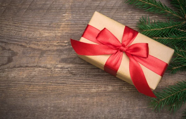 Caja de regalo con cinta roja sobre fondo de madera —  Fotos de Stock