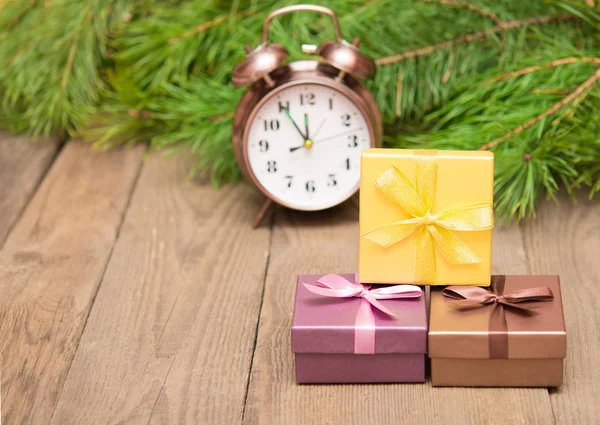 Подарункові коробки з ялинкою і годинником на дерев'яному фоні — стокове фото
