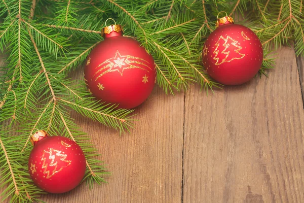 Weihnachtskarte mit Tannenbaum und roten Kugeln auf Holz Stockbild