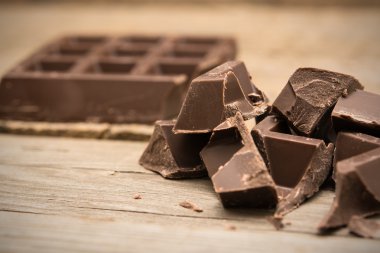 Ahşap arka plan üzerinde çikolata parçalarını