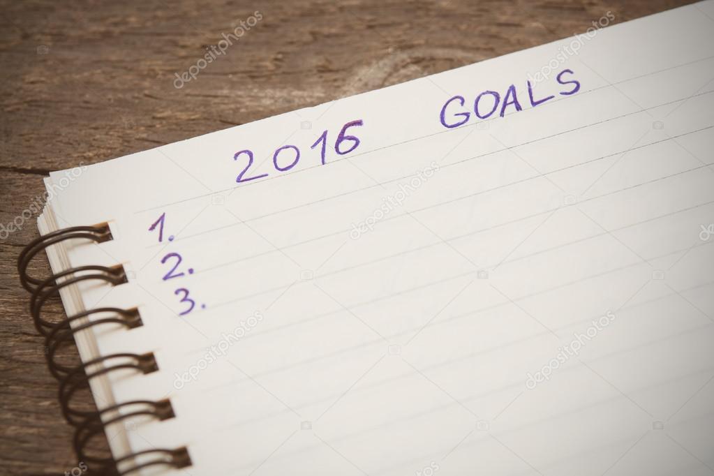 Notebook with goals of year 2016 on wooden background