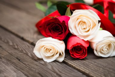 Red and white roses on a dark wooden background. Women' s day, V