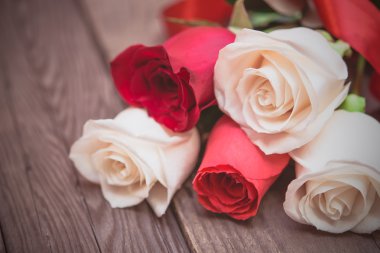Red and white roses on a dark wooden background. Women' s day, V