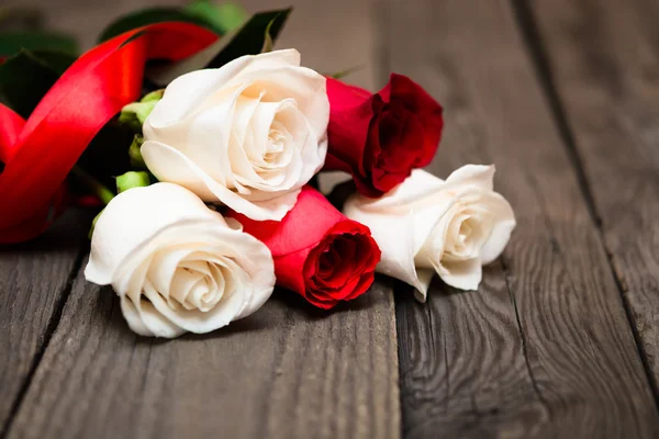 Red and white roses on a dark wooden background. Women' s day, V — Stockfoto