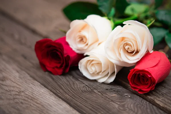Red and white roses on a dark wooden background. Women' s day, V