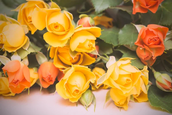 Rosas amarelas e laranja em um fundo de madeira leve. Mulheres 's d — Fotografia de Stock