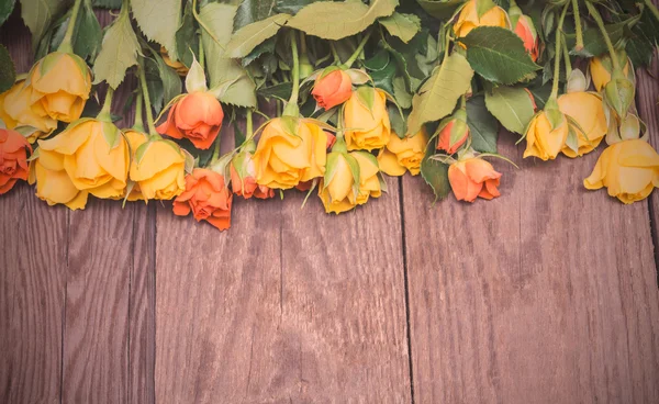 Yellow and orange roses on a wooden background. Women' s day, Va — Stock Photo, Image