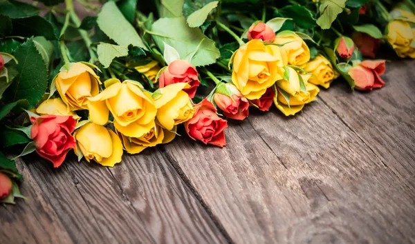Rosas amarelas e vermelhas sobre um fundo de madeira. Dia das mulheres, Valen — Fotografia de Stock
