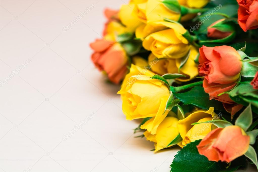 Yellow and orange roses on a light wooden background. Women' s d