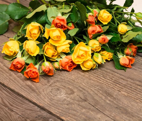 Yellow and orange roses on a wooden background. Women' s day, Va — Stock Photo, Image