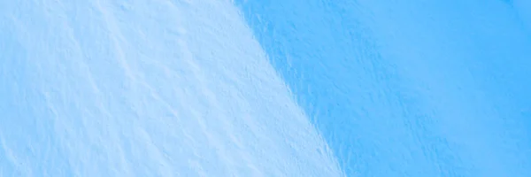 Snow texture. Wind sculpted patterns on snow surface. Wind in the tundra and in the mountains on the surface of the snow sculpts patterns and ridges. Arctic, Polar region. Winter panoramic background.