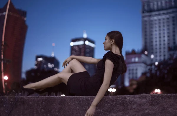 Szexi fiatal szépség pózol, mint éjszakai város háttér — Stock Fotó