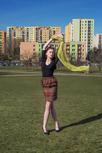 Meisje met vliegende sjaal op de achtergrond van de stad — Stockfoto