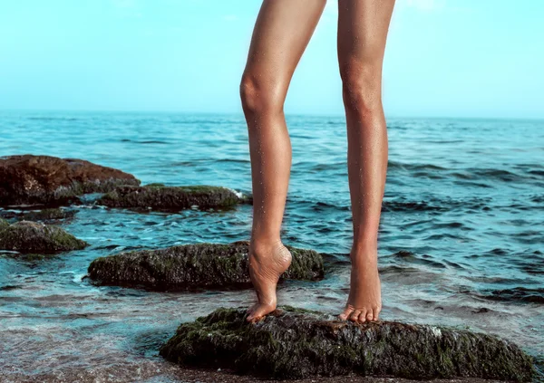 Pernas de mulher no molhe da praia — Fotografia de Stock