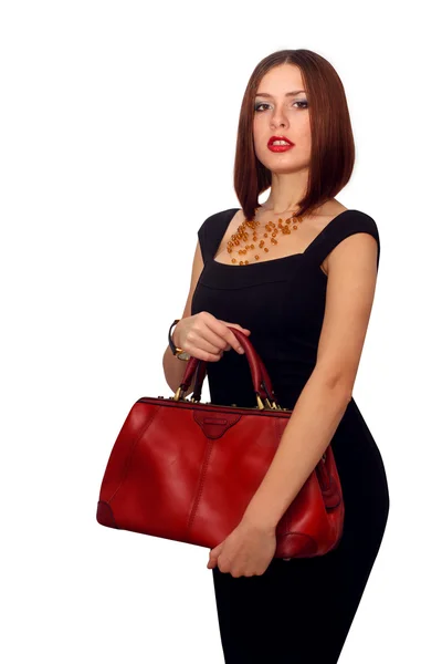 Fashionable sexy woman posing in elegant black dress with red leather handbag in hands — Stock Photo, Image