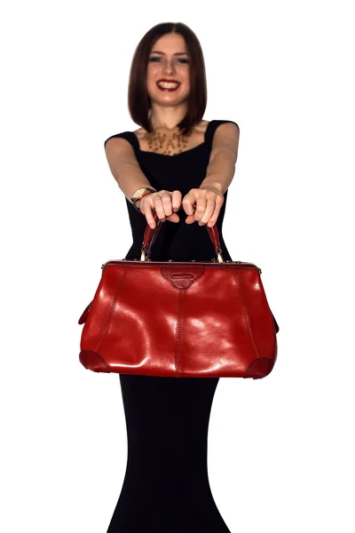 Fashionable sexy woman posing in elegant black dress with red leather handbag in hands — Stock Photo, Image