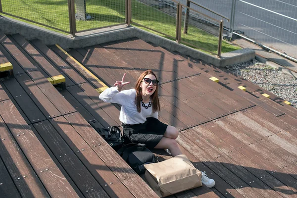 Vrouw met boodschappentassen zittend op de stappen — Stockfoto