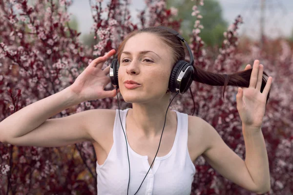 Beautiful girl listening to music on headphones — Stock Photo, Image