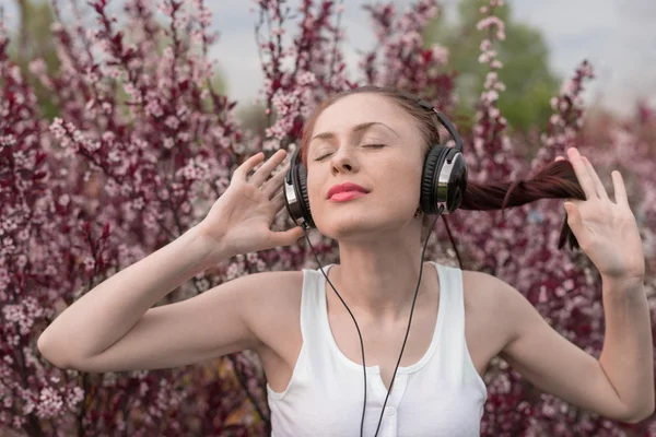 Beautiful girl listening to music on headphones — Stock Photo, Image