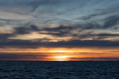 Denizin üzerinde dramatik günbatımı gökyüzü