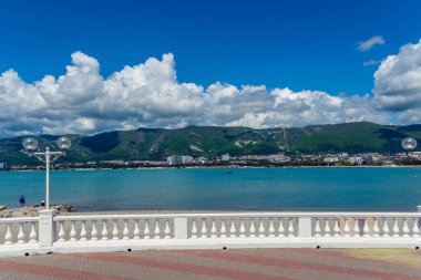 Denizin ve dağların arka planında balyoz ve fenerlerle dolu bir tatil köyü. Güzel beyaz kümülüs bulutları. Kıyı beldesi Gelendzhik