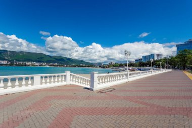 Denizin ve dağların arka planında balyoz ve fenerlerle dolu bir tatil köyü. Güzel beyaz kümülüs bulutları. Kıyı beldesi Gelendzhik