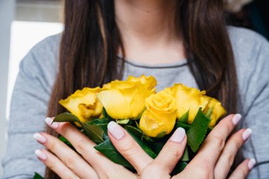 Sarı gülleri tutan eller