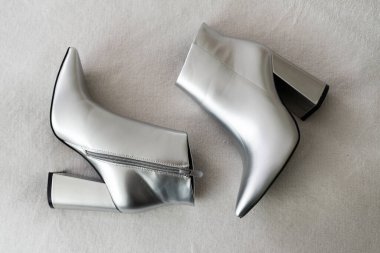 Beyaz arka planda gümüş yüksek topuklu ayakkabılar