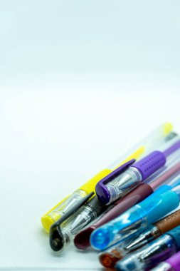 beyaz arkaplanda renkli jel kalemler