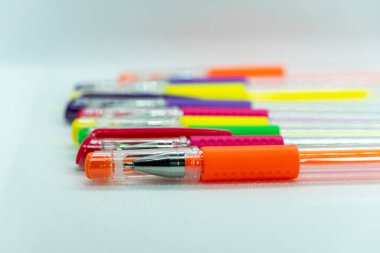 Beyaz arkaplanda renkli jel kalemler