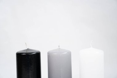 Beyaz arkaplanda siyah, gri ve beyaz renkli şık mumlar