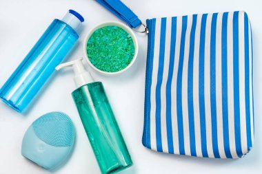 Kozmetik düz yatak: sağlık ürünleri, banyo tuzu ve beyaz arka planda yeşil ve mavi renkli yüz masajı. Doğal organik ürün, güzellik ve spa konsepti