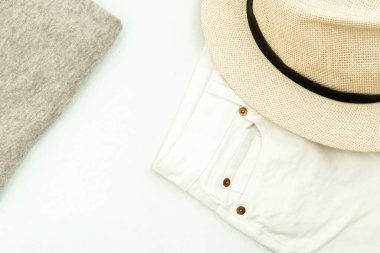 Yaz düzlüğü: gri bir kazak, beyaz kot pantolon ve kadın şapkası.