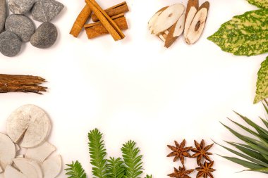 Doğal elementlere sahip beyaz arkaplan: Tahta, taş, tarçın çubukları, yeşil dallar.