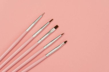 Kozmetik düz yatak: pembe arka planda pembe makyaj fırçaları