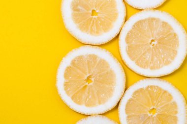 Sarı arka planda taze sarı limon dilimleri